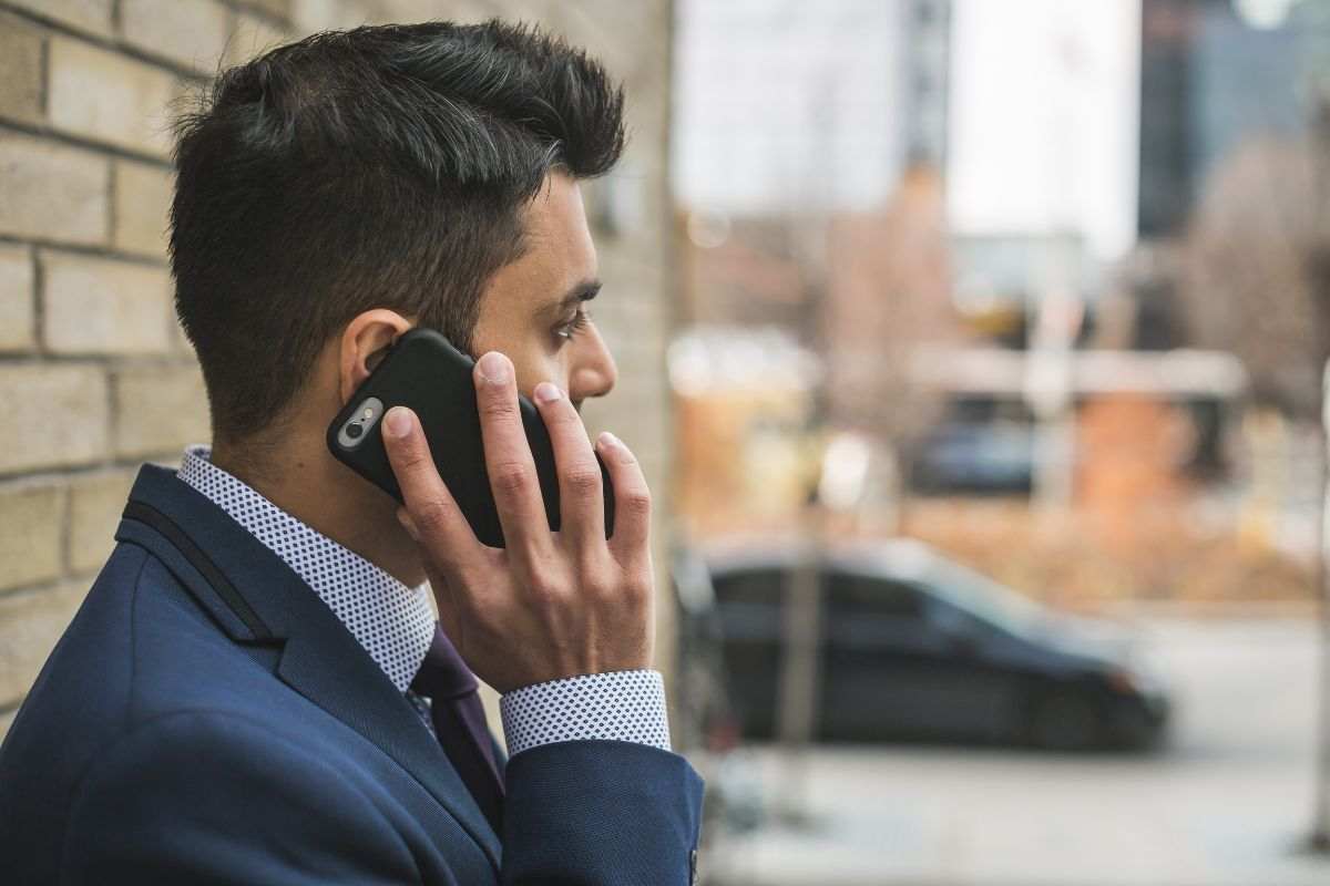 Ragazzo vestito elegante impegnato in una telefonata